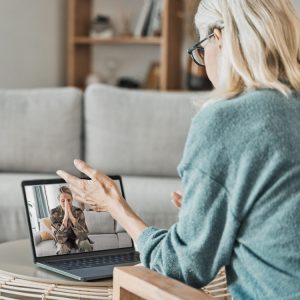 two women video conferencing on a laptop